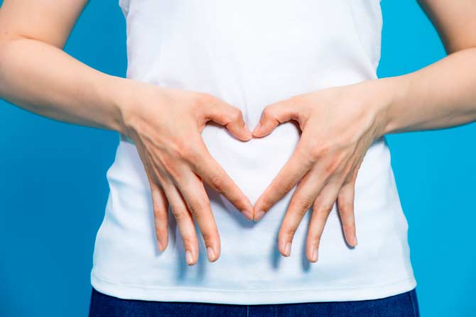woman with her hands on her stomach in a heart shape - looking for compounded meds without lactose, gluten, sugar