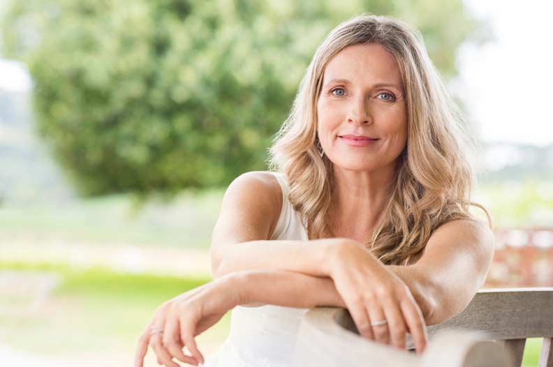 middle aged woman smiling benefiting from low-dose naltrexone